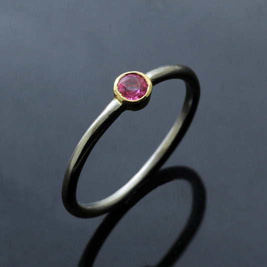 ROUND BRILLIANT CUT PINK SAPPHIRE SET IN 18CT WHITE GOLD WITH 18CT YELLOW GOLD COLLET